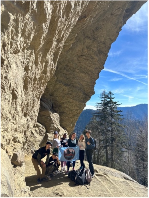 Students under arch on a mountain.